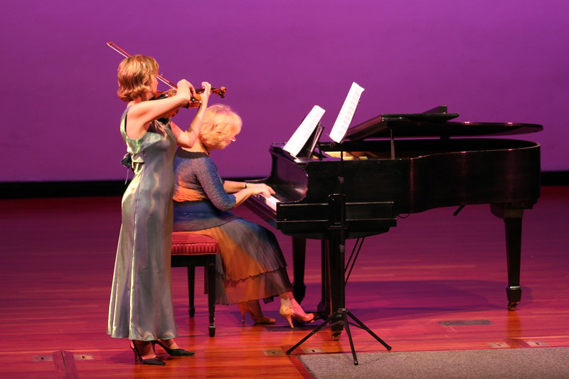 a woman playing a violin and a woman playing a piano